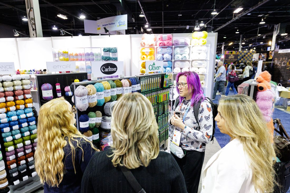 An exhibitor sharing a catalog at h+h americas